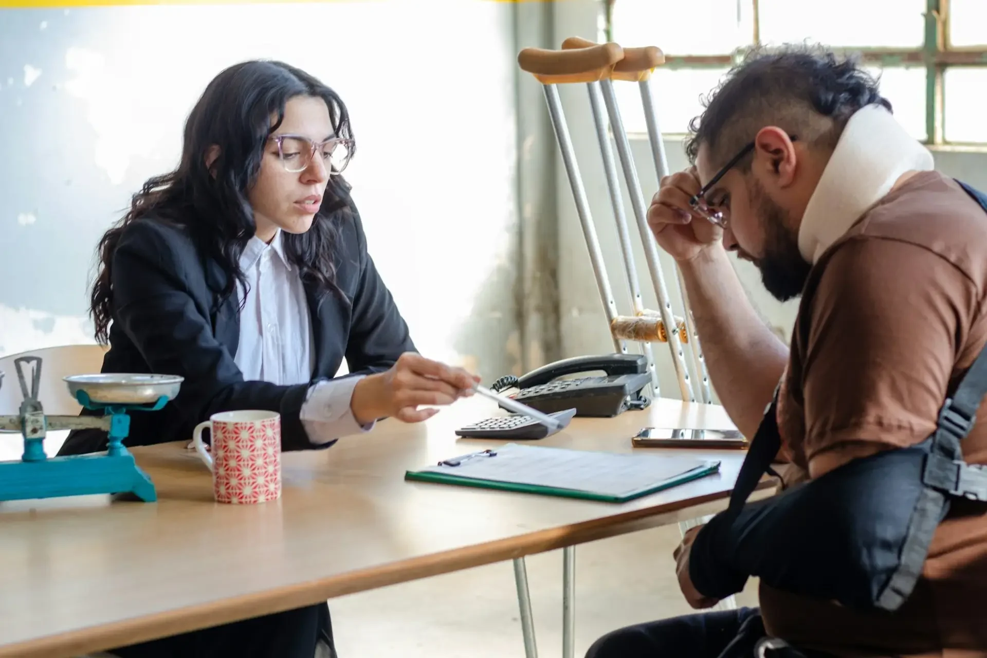 personal injury lawyer reviewing documents with a client who has sustained injuries
